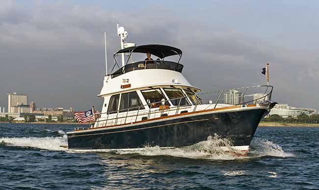 Wide shot of Eastbay 46 powerboat underway. Red white and blue flag blows off back of boat