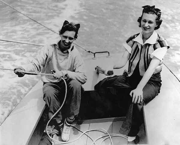 Fairfax Moody Hamilton (right) takes the tiller, while her sister, Betty Moody, mans the sails