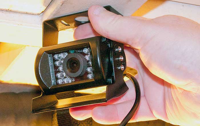 A hand holding a camera up to a white ceiling