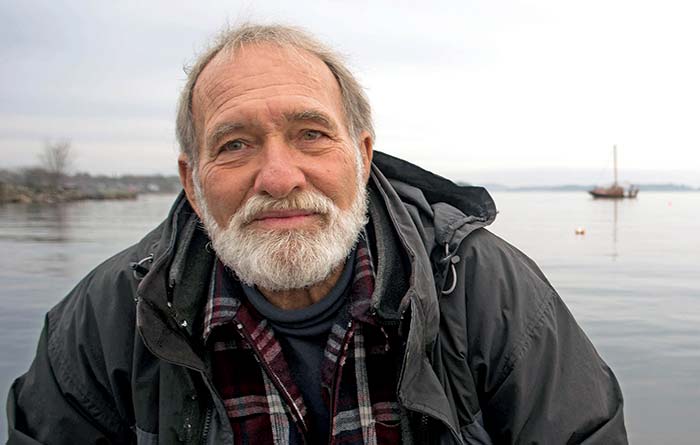 A man with a beard smiling with his mouth closed