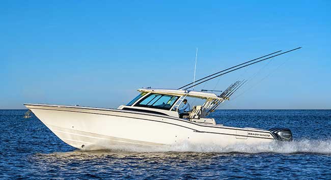 A side view of a white powerboat underway