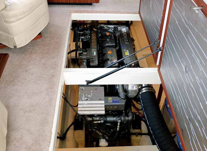 Boat batteries, inboard engine and hoses visible with deck plates removed