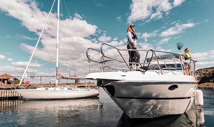 Woman and child standing aboard a powerboat moored on the water