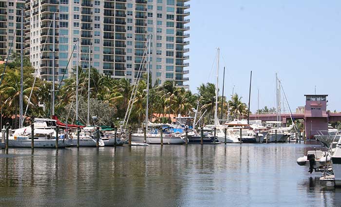 Boats docked at a marina with high-rise building in the background