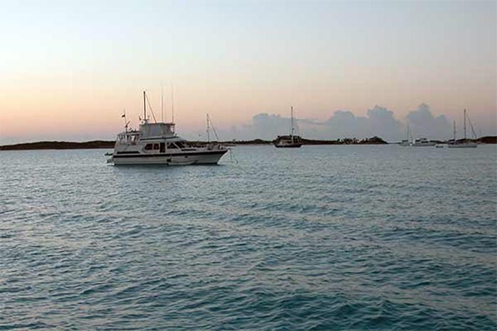 Boat anchored on calm water during sunset