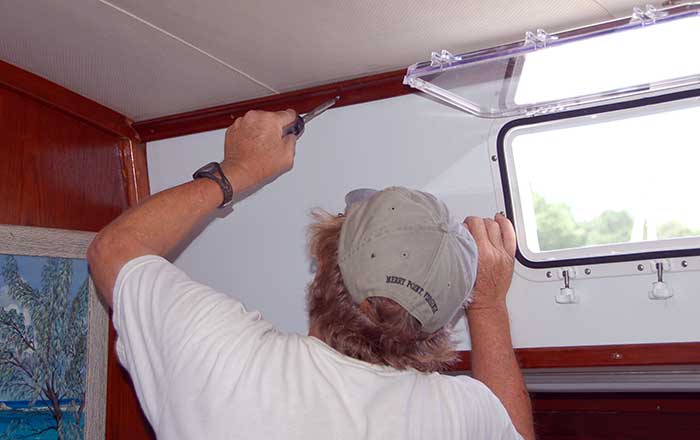 Fastening the new Komatex panel in place with screws