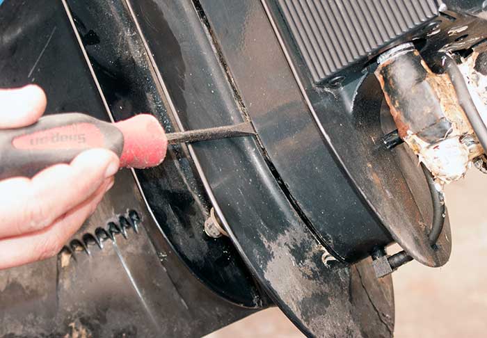 Using a screwdriver to pry lower unit apart