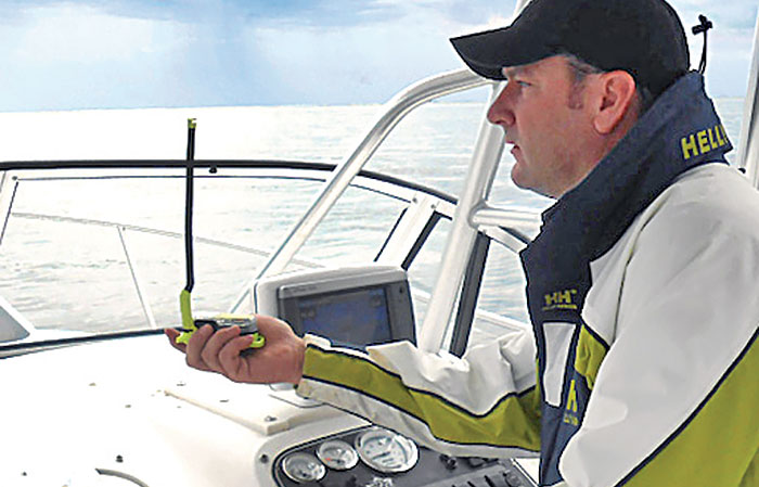 Man using an EPIRB aboard a powerboat