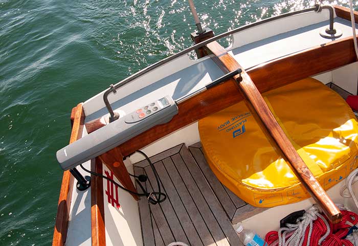 Bow-view of a tiller-steered boat small boat cruising along the water