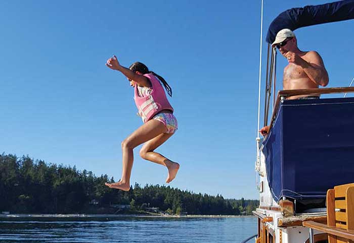 Payson leaps into the water from the fly bridge