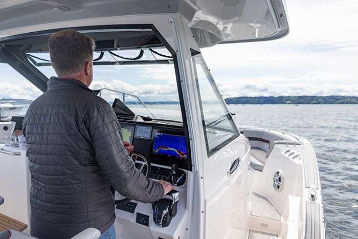 Man at helm of Solara S-310 CW center console walkaround powerboat