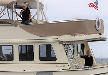 Tom and Mel Neale aboard their powerboat waving