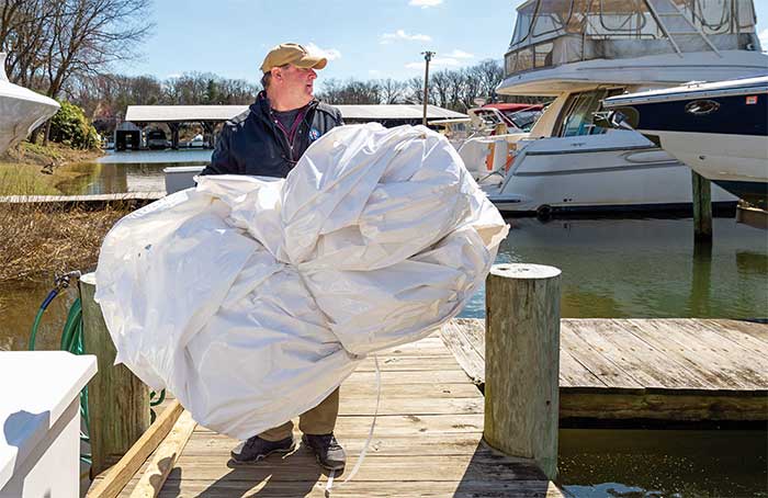 Man holding discard pile of shrinkwrap