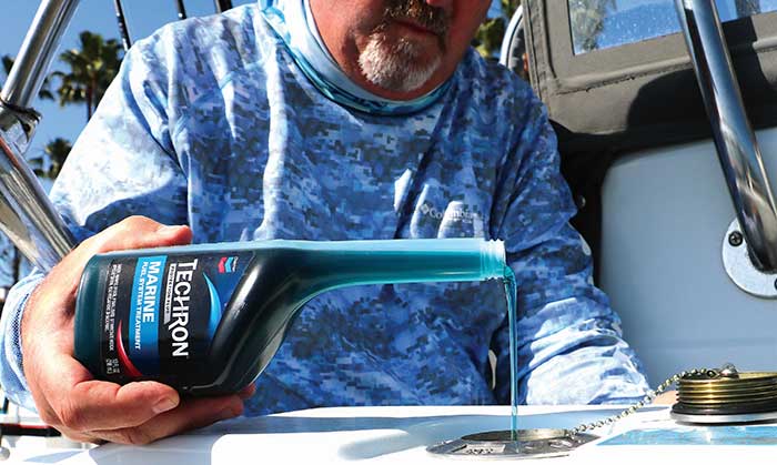 Product photo: Man with a beard filling a boat engine with Techron Marine Fuel System Treatment