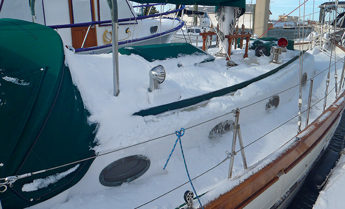 A snow covered white vessel docked