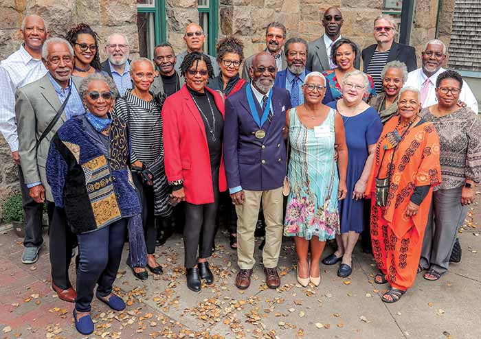 Group of people standing in front of a stone building