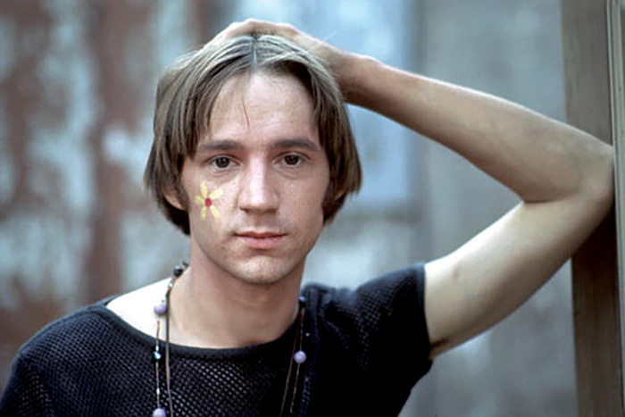 Young David Crosby wearing a black t-shirt with a flower painted on his cheek