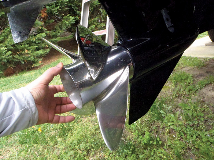 Photo of a man inspecting the propeller of his boat.