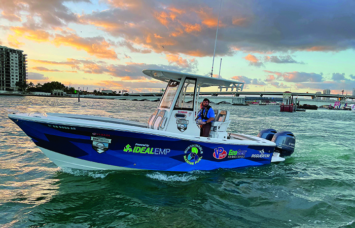 Large blue and white vessel driven by an adult male in the open waters at sunset.