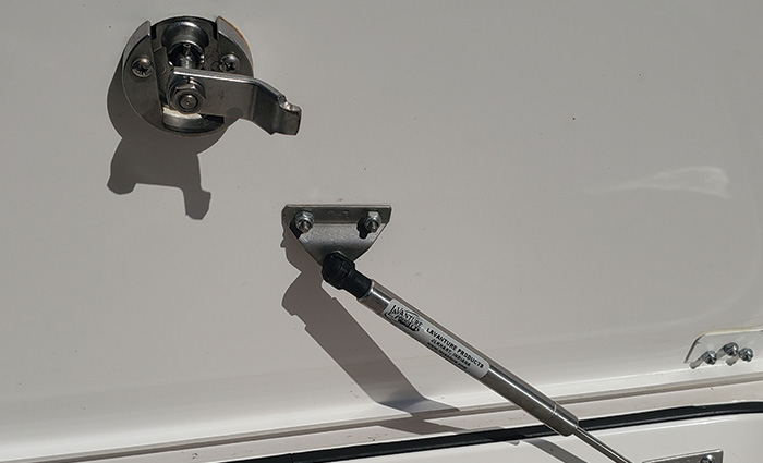 A white boat's silver hatch on a fishbox.