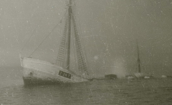 Black and white photo of a sinking sailboat.