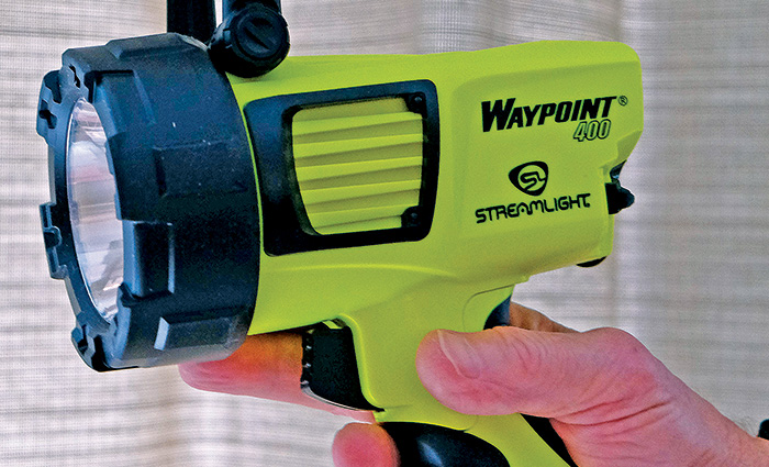 Neon green and black rechargeable spotlight being held.