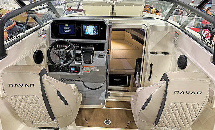 Helm of a vessel with two large white captains chairs and hydraulic stearing.