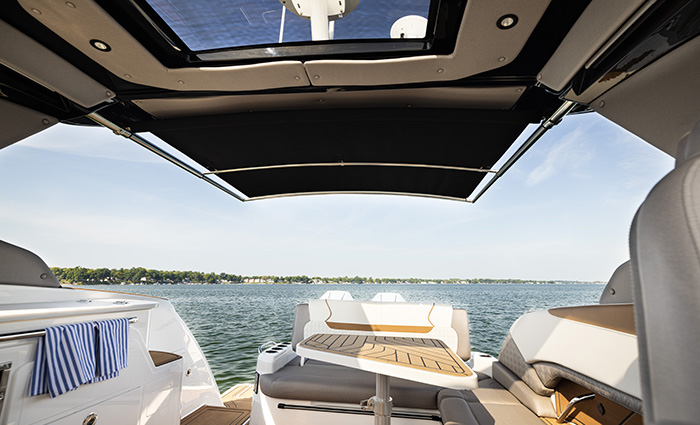 Seating area on a vessel overlooking clear sunny skies and blue water.