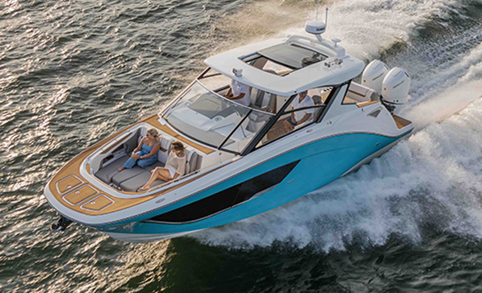 Aerial view of large blue, black and white vessel speeding through the water.