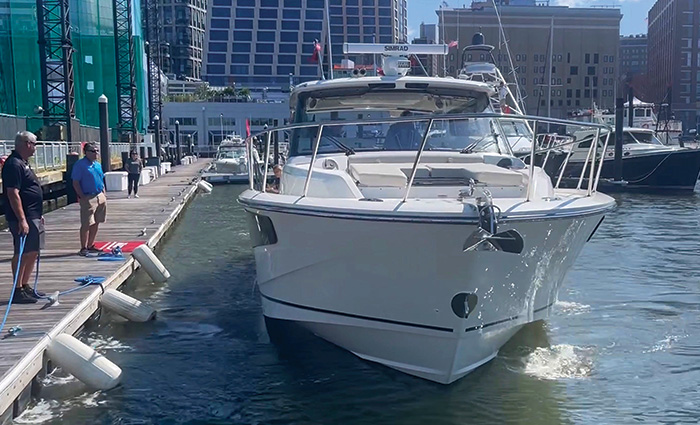 Two adult males watching as a white vessel docks.