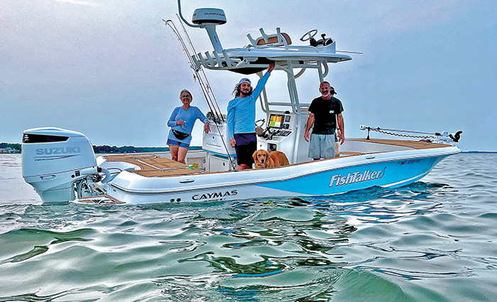 Four adult passengers on a blue and white boat in open waters at sunset.