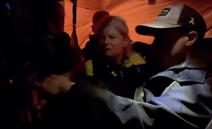 An adult blonde female in the process of being evacuated from a ship.