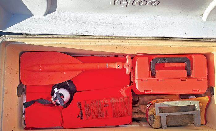 Large white 120-quart cooler storing a red life jacket, red paddle, red tool box and other supplies.