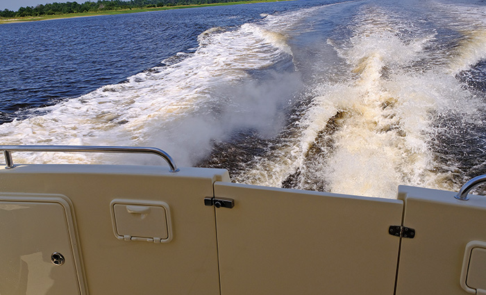 View of chop from the back of a vessel while out on open waters.