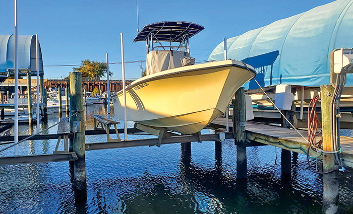 Front view of a white vessel on a large lift with sunlight reflecting off the bow.