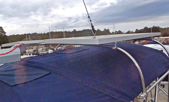 Large solar panel mounted to a covered vessel docked in a harbor.