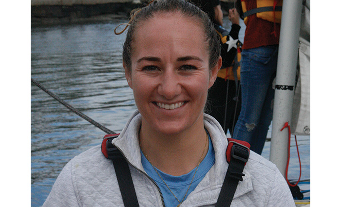 Young adult Caucasian female with brown hair pulled in a pony tail posing for a photo while on a boat. 