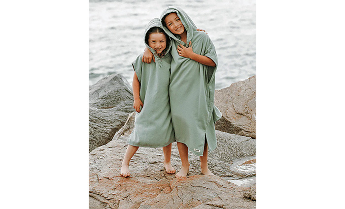 Two female children wearing matching light-green ponchos