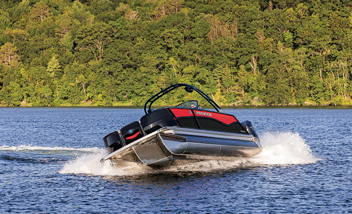 Black and red pontoon boat taking a sharp turn on open waters.
