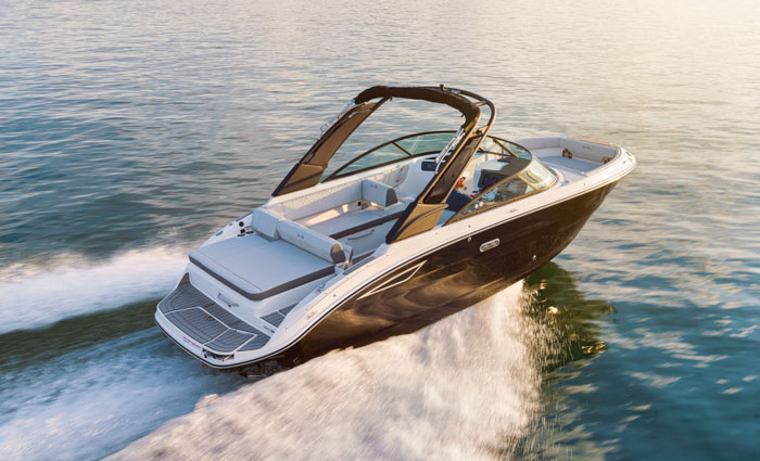 A black and white vessel cutting through open waters at sunset.