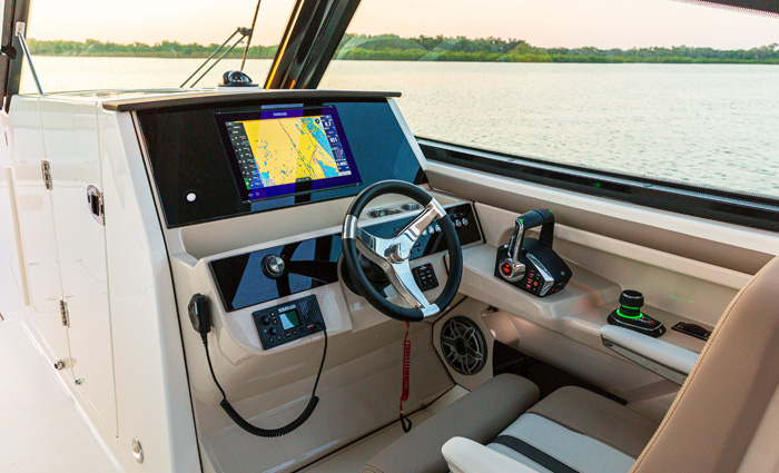 View of a vessel console helm featuring white and tan interior with a black navigation and display.