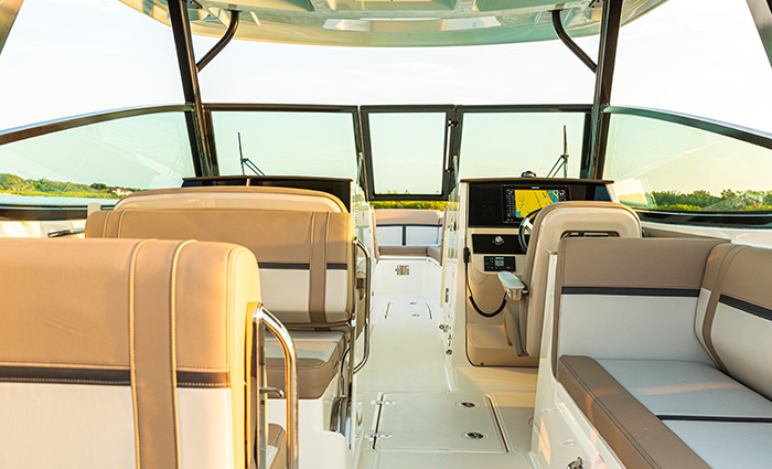 Tan and white seats with black trim on a vessel out on the water.