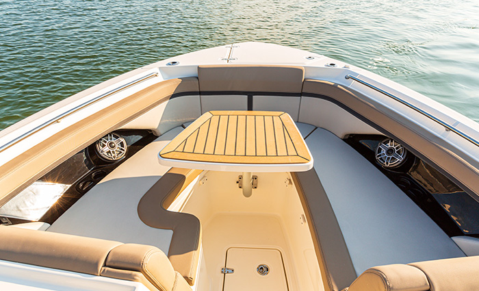 View from above of a boat bow featuring white and tan seating.