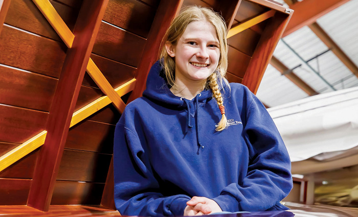 Blonde young female wearing a blue hooded sweatshirt 