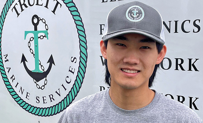 Young adult male wearing a gray hat and gray shirt posing for a photo.