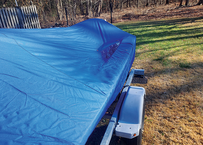 Water pooled on the edge of a blue boat cover.