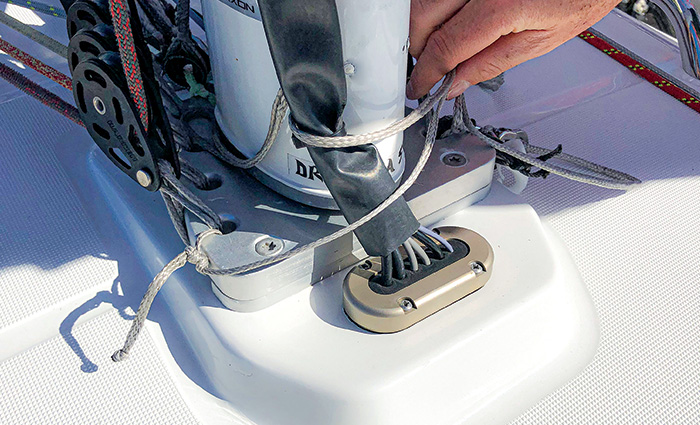 Deck gland on a white boat with cables running through it.