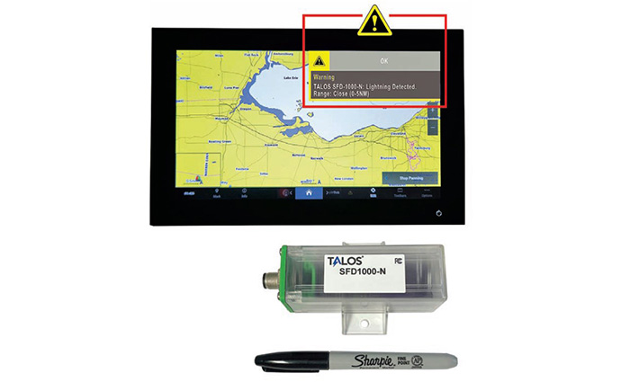 Display monitor showcasing radar, green and clear Talos portable lightening detector and a Sharpie pen.