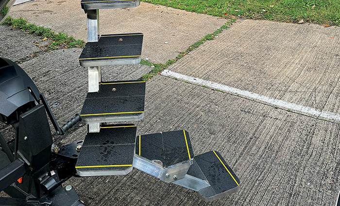 Black step ladder with yellow stripes on the side of a black boat.