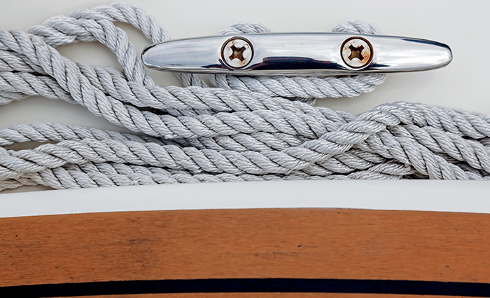 Clean on the side of a white vessel with rope tied around it.